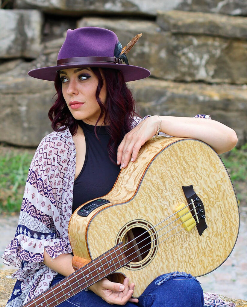 Danielle Nichole sitting and holding a guitar